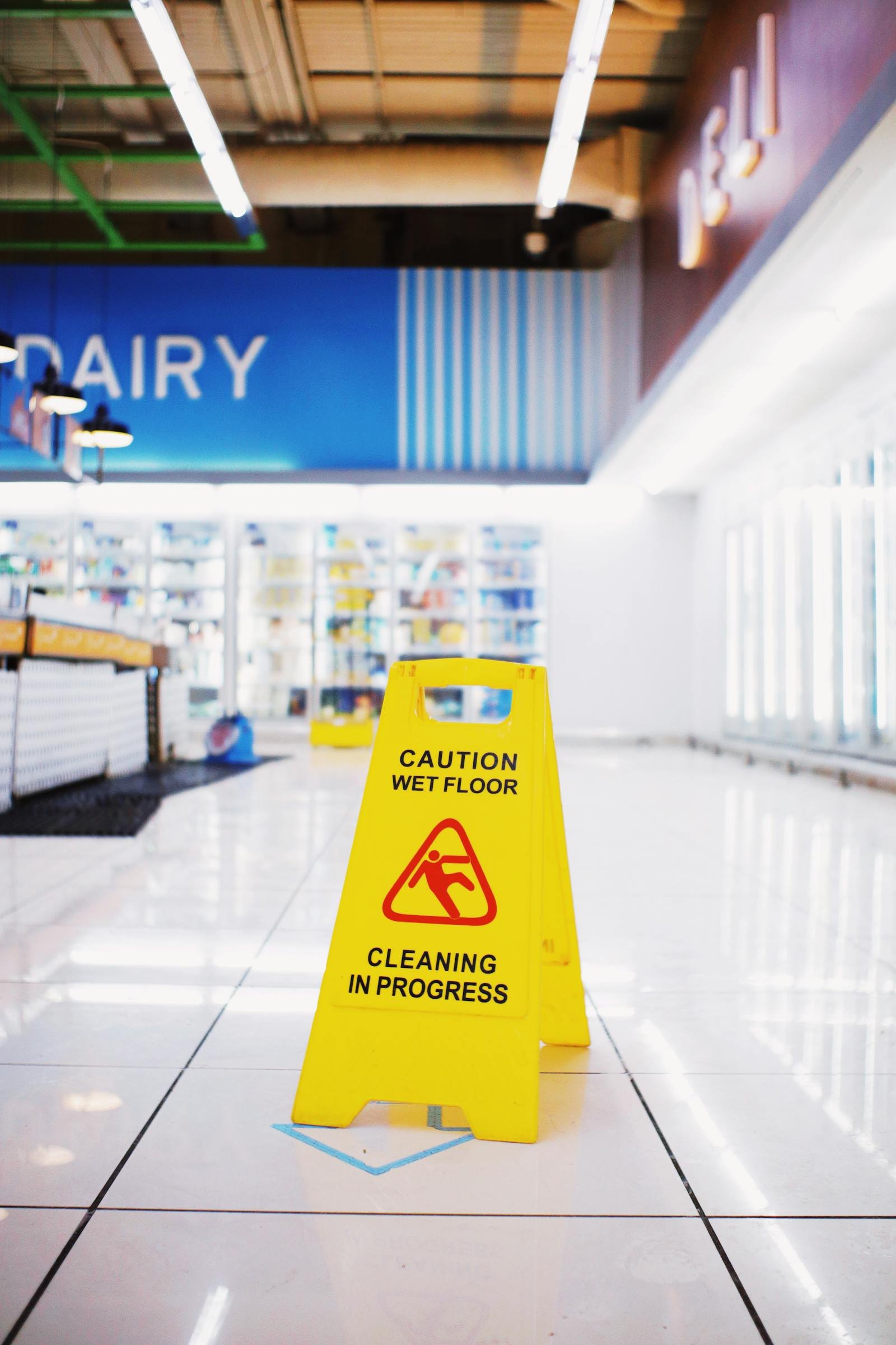 Retail store floor cleaning with wet floor sign in Manchester