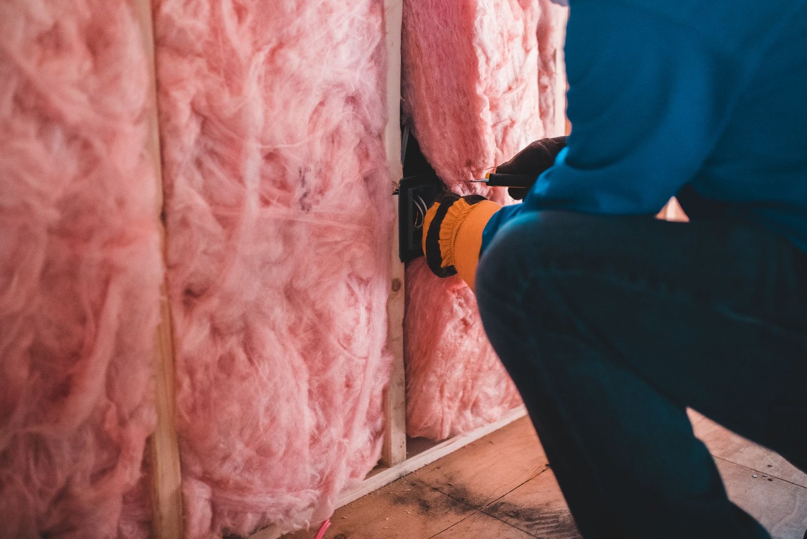 Worker fitting stone wool insulation in a Manchester loft