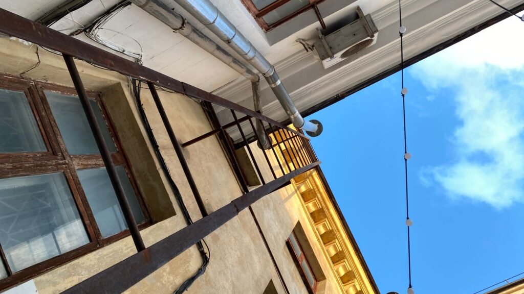 Roof gutters and downpipe on a house exterior under a clear sky