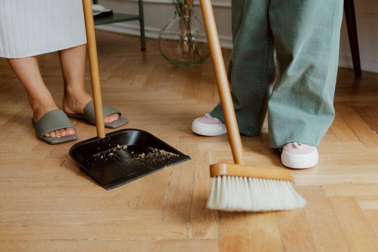 Sweeping a wooden floor with a dustpan and brush during a spring clean