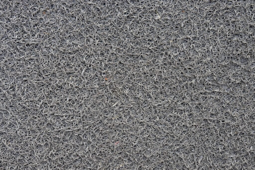 Close view of grey looped carpet pile texture