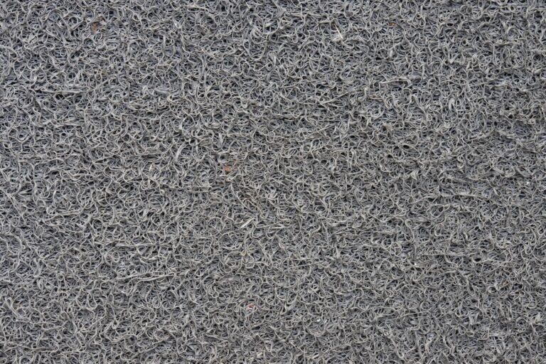Close view of grey looped carpet pile texture