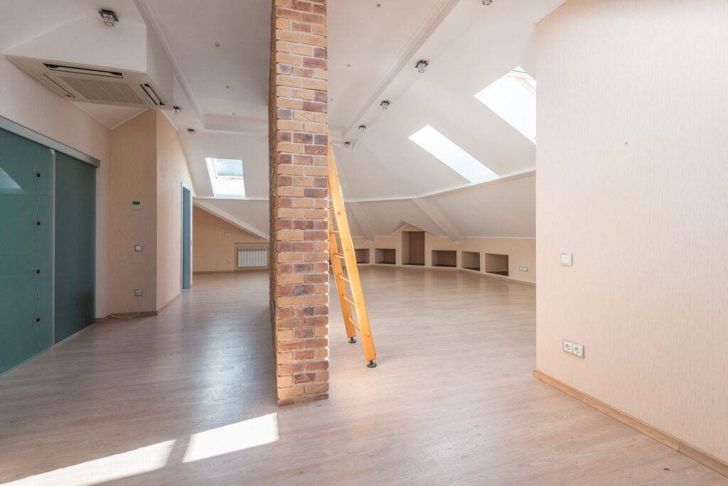 A bright empty loft room with skylights