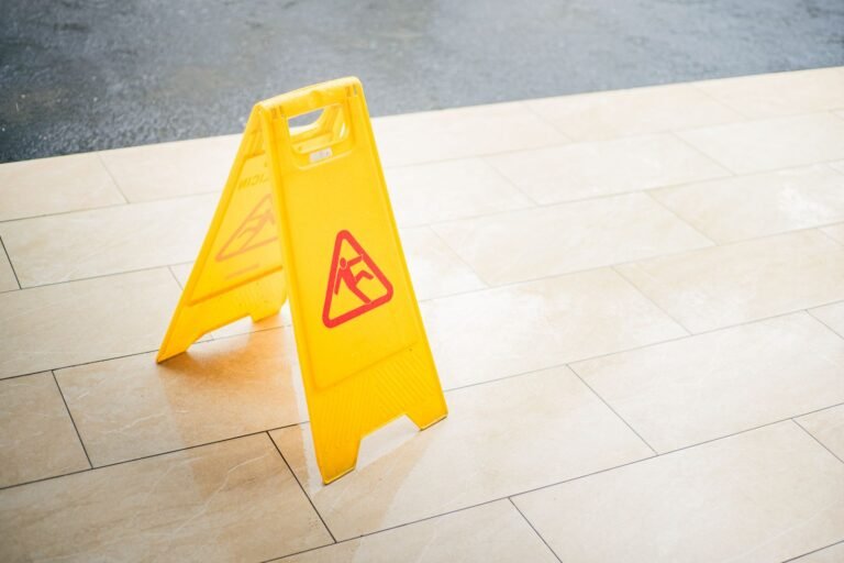 A yellow wet floor caution sign on a tiled floor